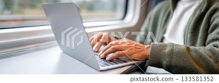 Man working remotely on laptop while traveling by train, showcasing productivity and modern lifestyle with copy space for text Man working remotely on laptop while traveling by train, showcasing productivity and modern lifestyle with copy space for text 133581352