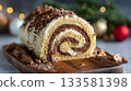 Macro photo of a beautifully swirled buche de noel on a wooden board, showcasing festive crumbs and holiday decorations in the background 133581398