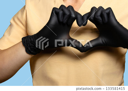 Female doctor, healthcare worker. A close-up, with the fingers of both hands forming a heart at chest level. Female doctor, healthcare worker. A close-up, with the fingers of both hands forming a heart at chest level. 133581415
