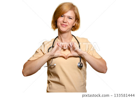 A female doctor, a healthcare worker, shows a heart with both hands folded at chest level. A female doctor, a healthcare worker, shows a heart with both hands folded at chest level. 133581444