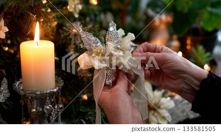 Hands delicately tying a velvet ribbon around a Gothic ornament with celestial motifs, surrounded by warm candlelight for a moody Gothmas atmosphere Hands delicately tying a velvet ribbon around a Gothic ornament with celestial motifs, surrounded by warm candlelight for a moody Gothmas atmosphere 133581505