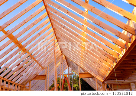 Workers are framing wooden joins rafters roof beams structure at house construction site. 133581812