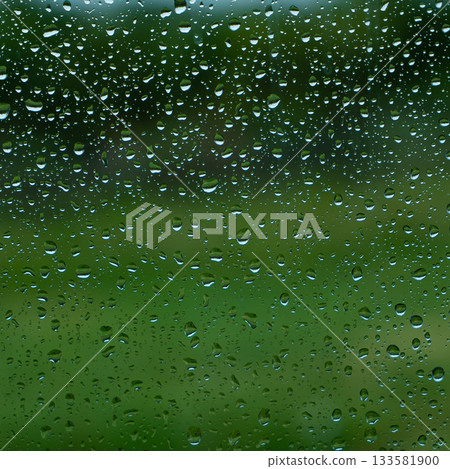 A rainy day window view. Rain drops on window. Condensed rain drop on the car glass window on a rainy day. Dew moisture condensation on wet mirror background. Fresh weather. Water raindrop bg 133581900