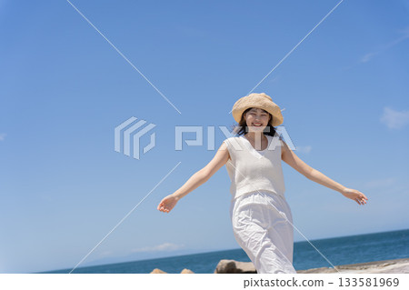 A woman walking along the beach A woman walking along the beach 133581969