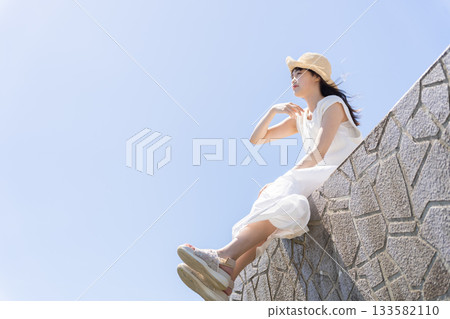 A woman sitting in a breakwater A woman sitting in a breakwater 133582110