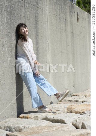 站立在牆壁前面的婦女 站立在牆壁前面的婦女 133582286