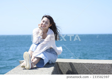 A woman relaxing on the coast A woman relaxing on the coast 133582397