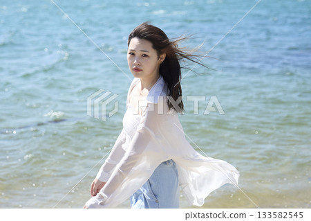 A woman walking along the beach A woman walking along the beach 133582545
