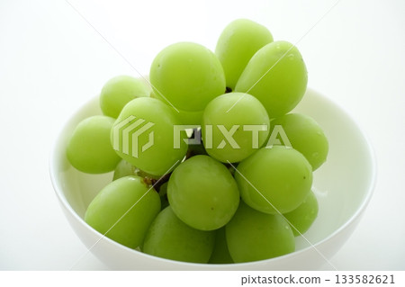 Fresh Shine Muscat grapes served in a white bowl 133582621