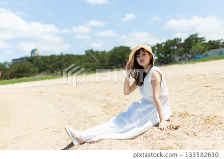 A woman sitting by the beach A woman sitting by the beach 133582630