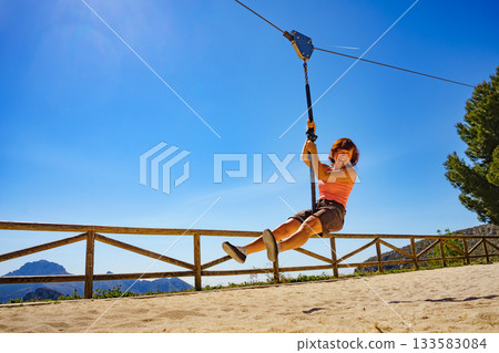 Adult woman having fun on zipline 133583084