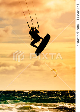 Kite surfer riding waves. Kiteboarding sport. 133583131