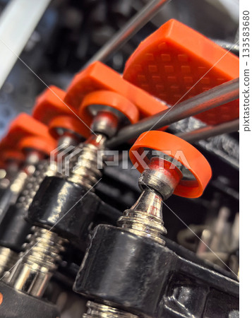 Close-up view of industrial machinery with vibrant orange components Close-up view of industrial machinery with vibrant orange components 133583680