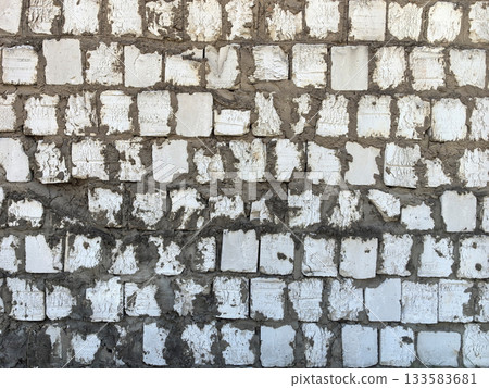 Textured wall of white bricks with cement at construction site 133583681