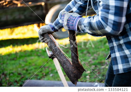 Crafting firewood from a sturdy log while embracing nature's tranquility during a sunny afternoon in the countryside Crafting firewood from a sturdy log while embracing nature's tranquility during a sunny afternoon in the countryside 133584121