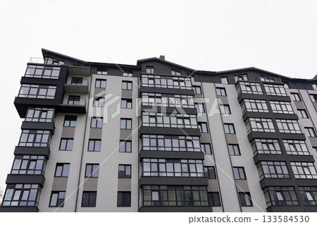 Modern apartment building showcases sleek design and large windows on an overcast urban afternoon in the city 133584530