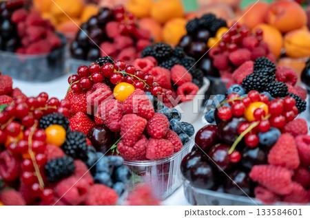 Prague, czech republic, august 9, 2023. Assortment of fresh organic berries including raspberries, blueberries, red currants, strawberries, and cherries in plastic containers at a market Prague, czech republic, august 9, 2023. Assortment of fresh organic berries including raspberries, blueberries, red currants, strawberries, and cherries in plastic containers at a market 133584601