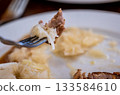 Prague, czech republic, august 9, 2023. Fork with tender roasted pork, tangy white cabbage sauerkraut and fluffy dumplings czech comfort meal close-up 133584610