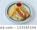 Ham and cheese hot sandwich and plate of french fries 133585104