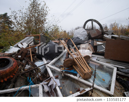 abandoned corrugated roofing remnants, dispersed stormdamaged metal sheets over field, weathered roofing panels strewn across open field exhibiting signs of neglect and deterioration 133585177