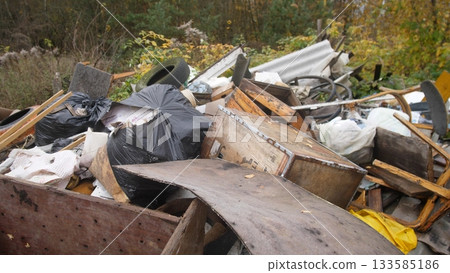 heap of mixed construction household debris on roadside with visible rust and loose insulation; plastic sacks, metal drums and broken panels suggest contamination risk and need for urgent heap of mixed construction household debris on roadside with visible rust and loose insulation; plastic sacks, metal drums and broken panels suggest contamination risk and need for urgent 133585186