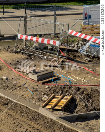 Construction site with safety fence and paving works 133585296