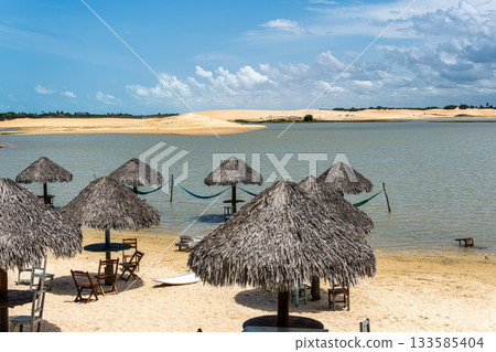 Straw huts on the banks of the Torta Lagoon, Tatajuba Beach at Jijoca de Jericoacoara, Ceara in Brazil 133585404