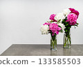 Bouquets of peonies in glass vases. Pink and white harmony of peonies. Fresh peonies on the table. Festiva Maxima, Duchesse de Nemours, Bowl of Cream, Kansas, Paul M. Wild. 133585503
