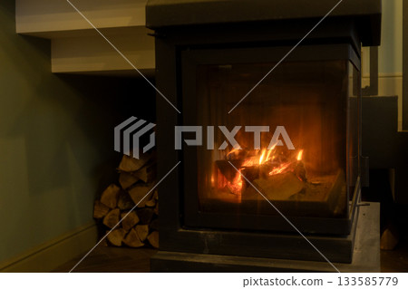 burning wood in the fireplace. the cozy atmosphere of a country house. burning wood in the fireplace. the cozy atmosphere of a country house. 133585779