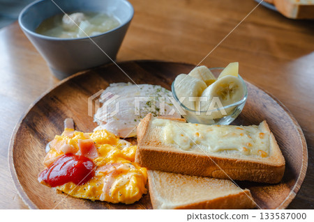 Western-style breakfast of cheese toast, scrambled eggs, chicken ham and banana 133587000
