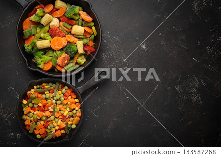 Frozen mixed vegetables two cast iron skillets black healthy cooking defrosting meal prep copy space 133587268