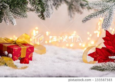 Red Gift Box with Gold Ribbon Among Christmas Decorations Red Gift Box with Gold Ribbon Among Christmas Decorations 133587383