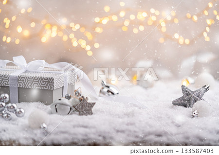 Elegant Gray Christmas Gift Box with White Ribbon on Snow 133587403