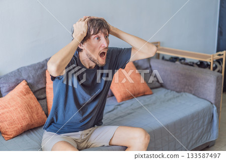 A man watching a football match on television at home, fully focused and relaxed in a cozy living room. Leisure time, sports entertainment, weekend relaxation and modern digital lifestyle concept A man watching a football match on television at home, fully focused and relaxed in a cozy living room. Leisure time, sports entertainment, weekend relaxation and modern digital lifestyle concept 133587497