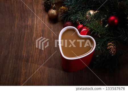 Heart Mug Holiday Scene. Heart-shaped mug with coffee, surrounded by festive holiday decorations 133587676