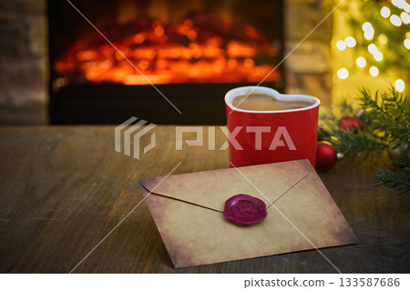 Cozy Holiday Scene. A heart cup and sealed letter by a warm fireplace, Cozy Holiday Scene. A heart cup and sealed letter by a warm fireplace, 133587686