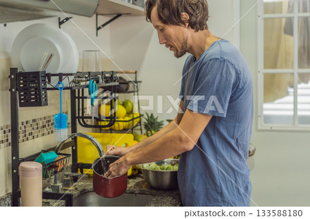 Man preparing lunch in an authentic modern kitchen with character, cutting ingredients and cooking a homemade meal in a warm family atmosphere 133588180