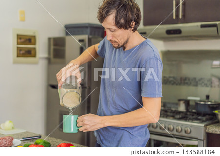 Man preparing lunch in an authentic modern kitchen with character, cutting ingredients and cooking a homemade meal in a warm family atmosphere Man preparing lunch in an authentic modern kitchen with character, cutting ingredients and cooking a homemade meal in a warm family atmosphere 133588184