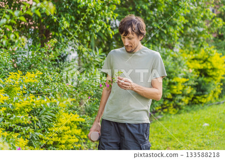 A man relaxing in a park on a sunny day, sitting peacefully on the grass and enjoying nature in a calm outdoor setting. Leisure time, mindfulness, mental wellness and slow living lifestyle concept A man relaxing in a park on a sunny day, sitting peacefully on the grass and enjoying nature in a calm outdoor setting. Leisure time, mindfulness, mental wellness and slow living lifestyle concept 133588218