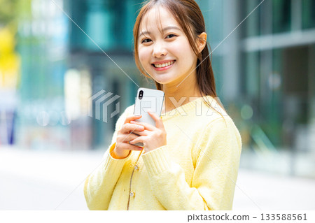 Woman holding a smartphone 133588561