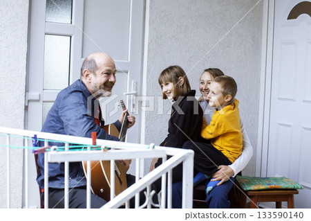 father of real family playing guitar singing, lifestyle people concept 133590140