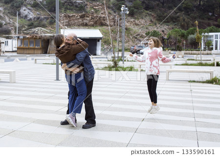 happy real family hugging outside, lifestyle people concept happy real family hugging outside, lifestyle people concept 133590161