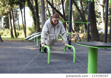 young pretty redhead woman making fitness on playground outside, lifestyle people concept 133590397