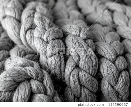 一張厚實的麻花針織毯的微距照片，展現了它柔軟溫暖的質感。 133590667