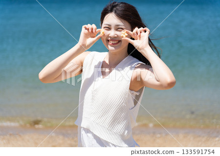 A woman fooling around with cookies at the beach A woman fooling around with cookies at the beach 133591754