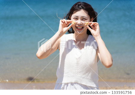 A woman fooling around with cookies at the beach A woman fooling around with cookies at the beach 133591756