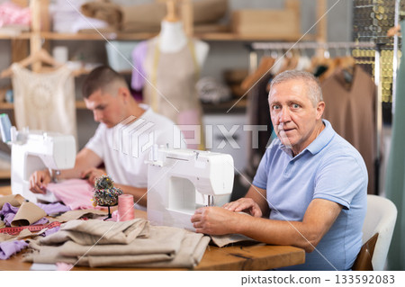 Two male workers in the atelier sewing 133592083