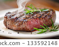 新鮮烤製的牛排，盛放在白色盤子上。 133592148