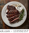 新鮮烤製的牛排，盛放在白色盤子上。 133592157