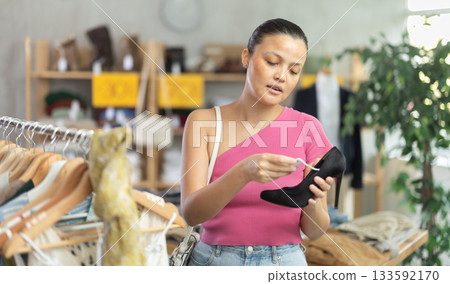Beautiful asian woman chooses fashionable shoes in prestigious store Beautiful asian woman chooses fashionable shoes in prestigious store 133592170